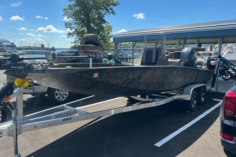 Slide: The Image of 2025 Xpress H22B Bay boat on trailer at marina, sunny day. - 14