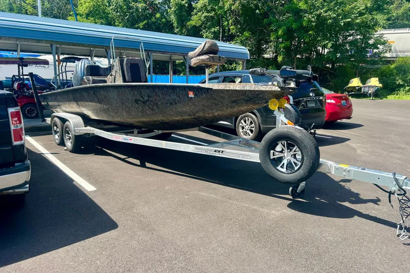 Slide: The Image of 2025 Xpress H22B Bay boat on trailer in parking lot, surrounded by cars. - 17