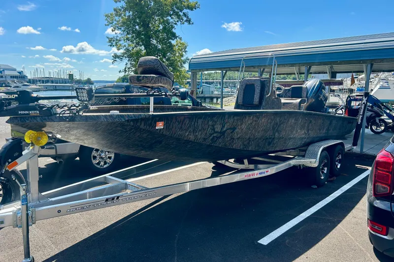 Slide: The Image of 2025 Xpress H22B Bay boat on trailer at marina, sunny day. - 18
