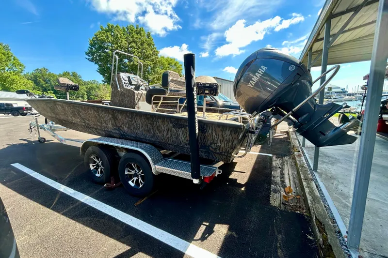 Slide: The Image of 2025 Xpress H22B Bay boat with Yamaha engine on trailer, parked outdoors. - 24