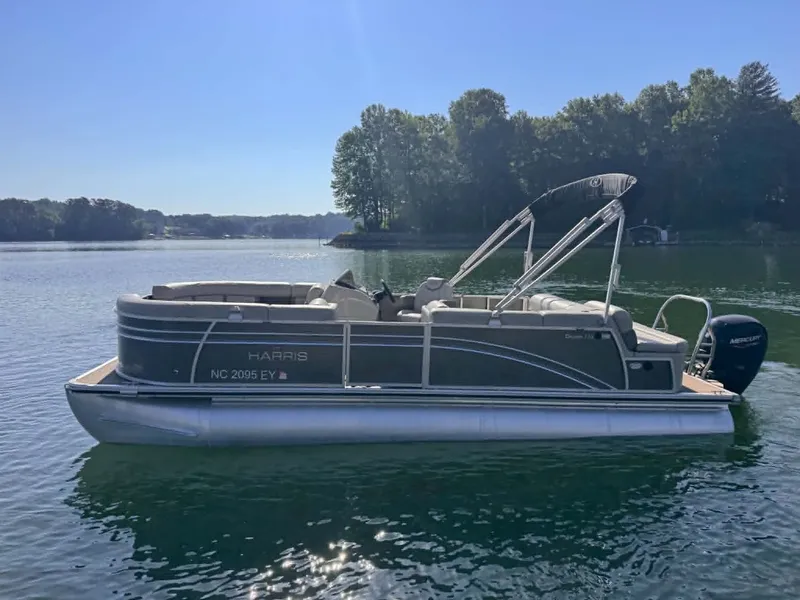 The Image of 2021 Harris Cruiser 230 pontoon boat on a calm lake. - 1
