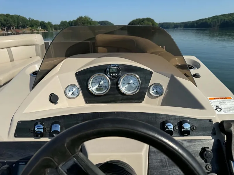 Slide: The Image of Dashboard of a Harris Cruiser 230 boat on a calm lake. - 12