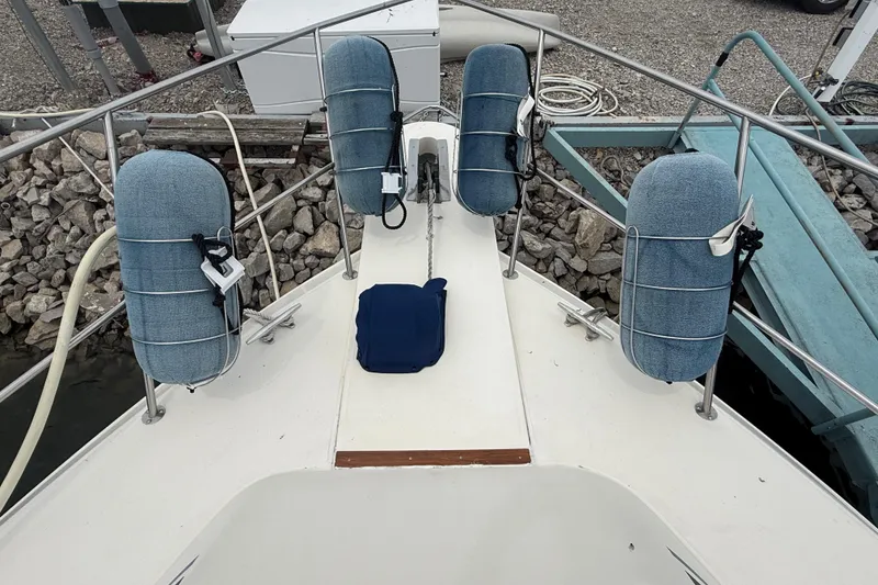 Slide: The Image of 1986 Sea Ray 410 Aft Cabin boat deck with blue fenders and railing. - 10