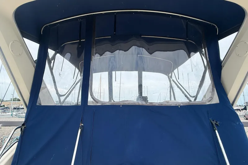 Slide: The Image of 1986 Sea Ray 410 Aft Cabin with blue canvas enclosure at marina. - 17