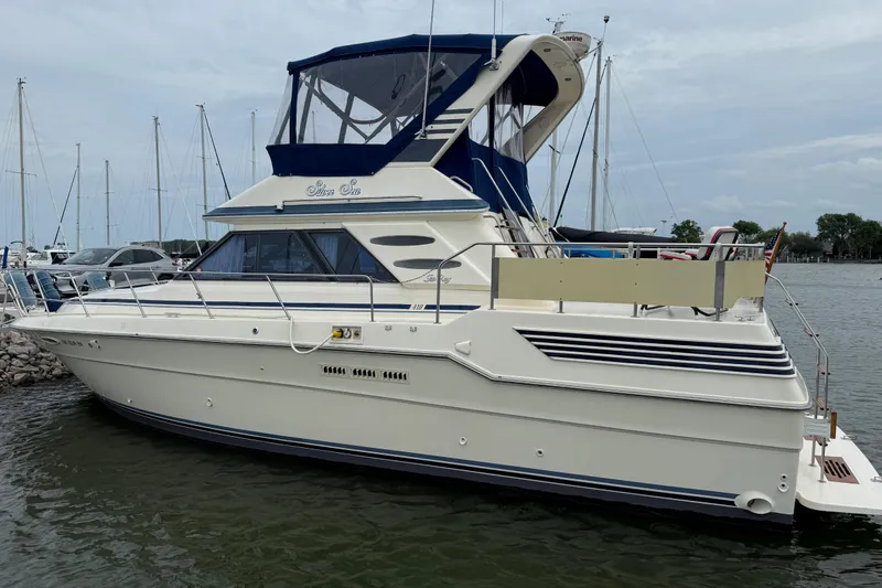 Slide: The Image of 1986 Sea Ray 410 Aft Cabin yacht docked at marina, featuring blue accents. - 2