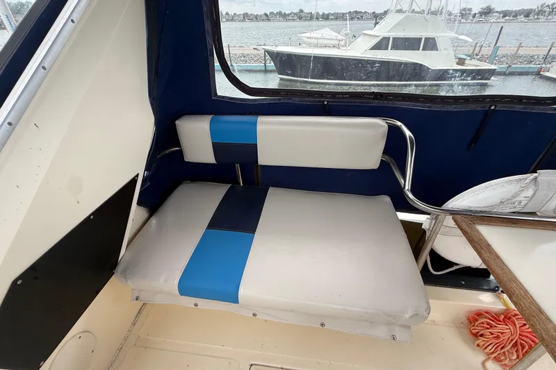 Slide: The Image of 1986 Sea Ray 410 Aft Cabin interior with blue and white seating, docked by the water. - 21