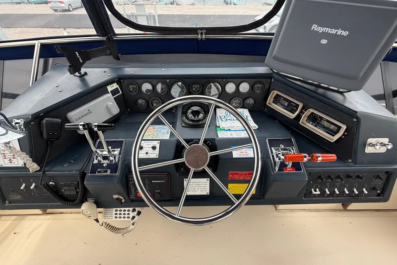 Slide: The Image of Cockpit of 1986 Sea Ray 410 Aft Cabin with steering wheel and navigation equipment. - 23