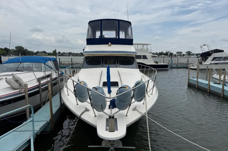 Slide: The Image of 1986 Sea Ray 410 Aft Cabin yacht docked at marina, front view. - 3
