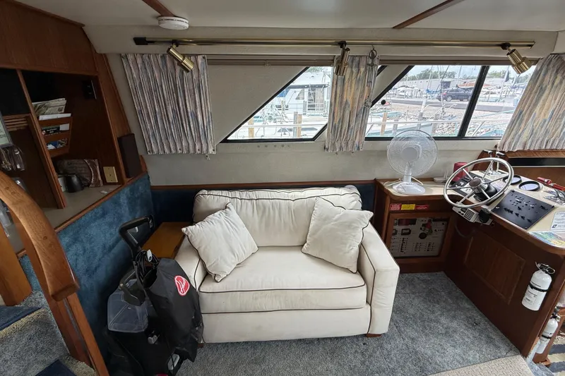 Slide: The Image of Interior of 1986 Sea Ray 410 Aft Cabin with sofa, helm, and nautical decor. - 34