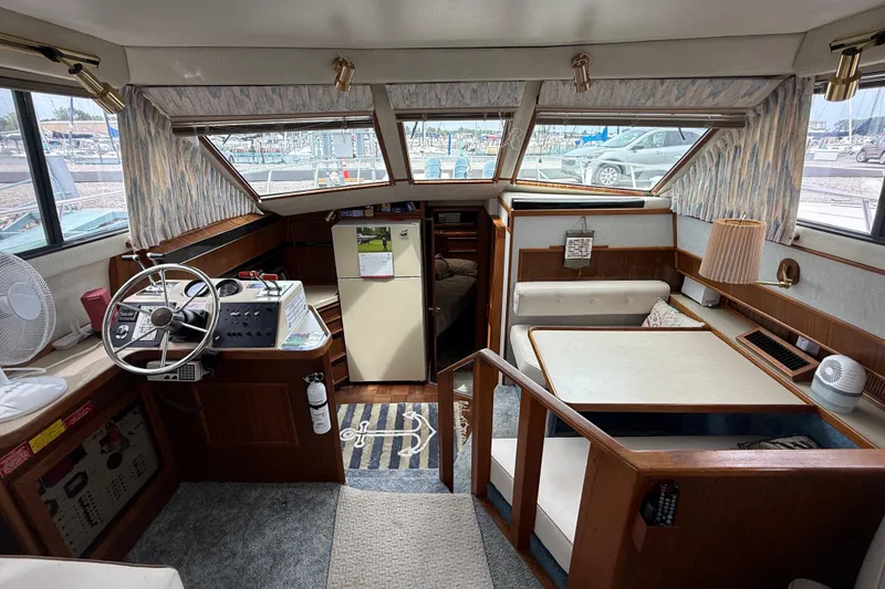 Slide: The Image of 1986 Sea Ray 410 Aft Cabin interior with helm, seating, and dining area. - 35