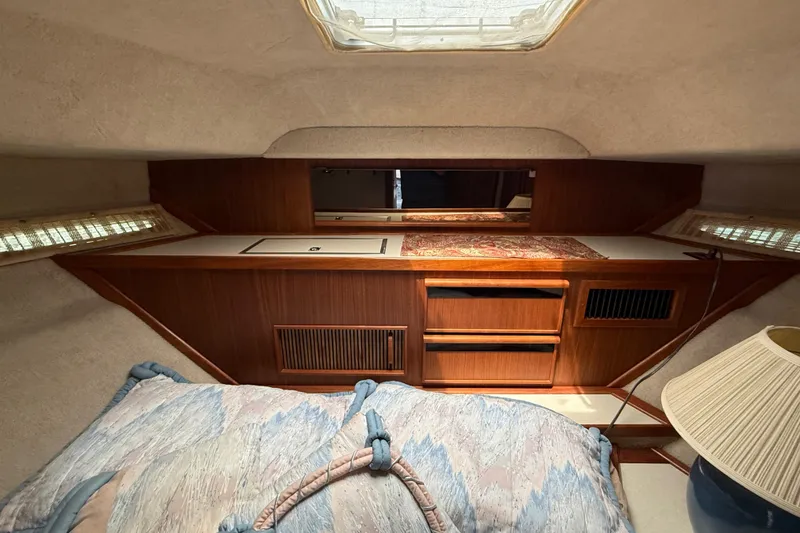 Slide: The Image of 1986 Sea Ray 410 Aft Cabin interior with wood cabinetry and cozy bedding. - 58