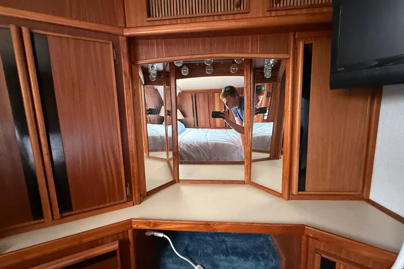 Slide: The Image of Interior of 1986 Sea Ray 410 Aft Cabin with wood cabinetry and mirrored vanity. - 71