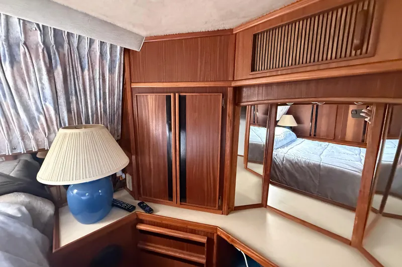Slide: The Image of Interior of 1986 Sea Ray 410 Aft Cabin with wood cabinetry and blue lamp. - 72