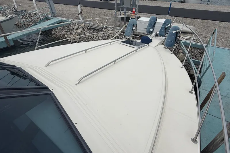 Slide: The Image of 1986 Sea Ray 410 Aft Cabin yacht deck with railings and seating. - 8