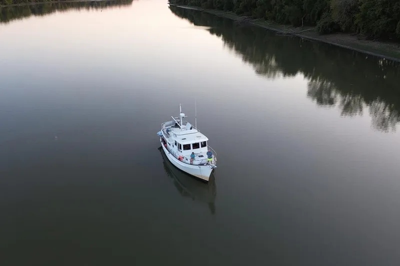 Slide: The Image of Kadey-Krogen 39 yacht from 2001 on calm river at sunset. - 2