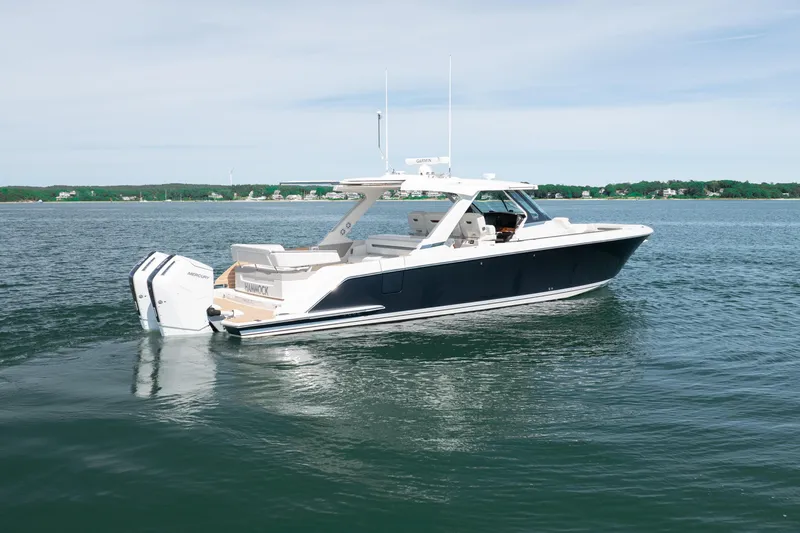 Slide: The Image of 2024 Tiara Yachts 43 LS luxury boat on calm water, showcasing sleek design and powerful engines. - 13