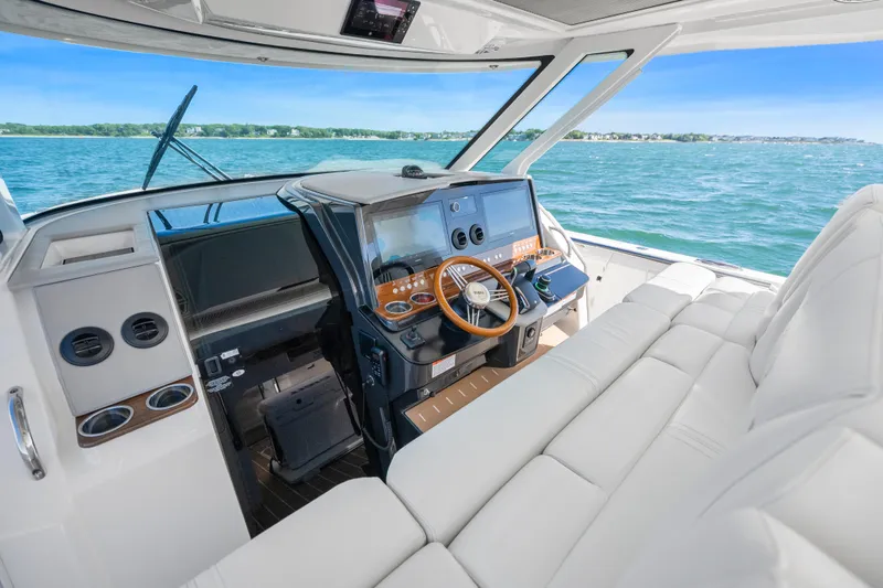Slide: The Image of 2024 Tiara Yachts 43 LS helm with luxurious seating and advanced navigation controls. - 20