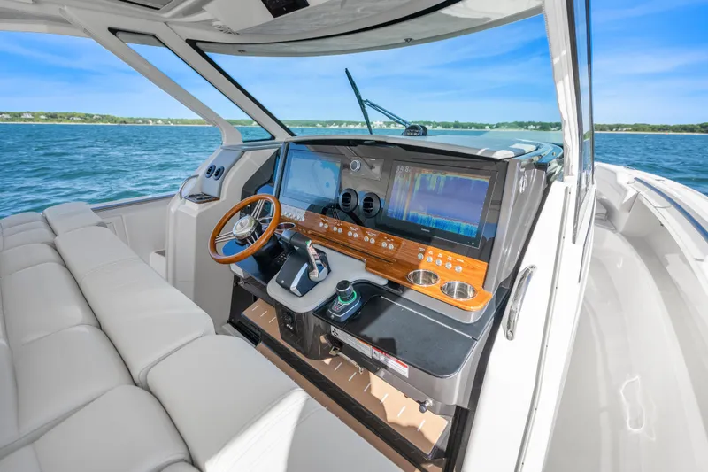 Slide: The Image of 2024 Tiara Yachts 43 LS helm with advanced navigation system and luxurious seating on open water. - 22