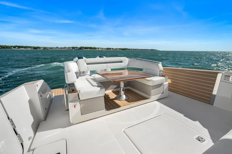 Slide: The Image of 2024 Tiara Yachts 43 LS luxury deck with seating, overlooking ocean under clear blue sky. - 30