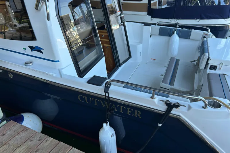 Slide: The Image of 2017 Cutwater C-24 boat docked, featuring open seating area and sleek design. - 1