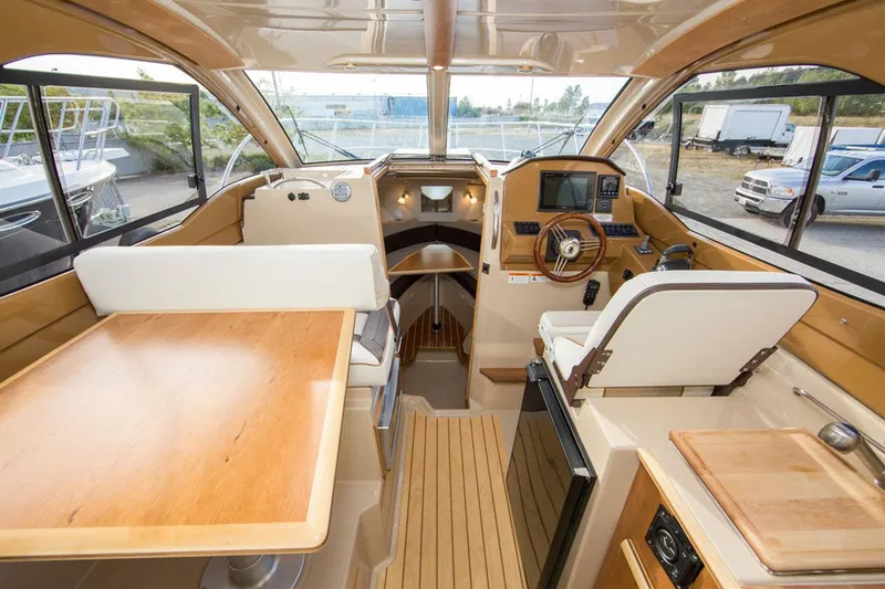 Slide: The Image of Manufacturer Provided Image: Interior of a 2017 Cutwater C-24 boat with helm, seating, and wooden table. - 10