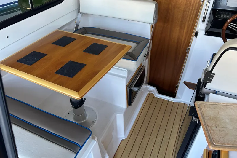 Slide: The Image of Interior of a 2017 Cutwater C-24 boat with wooden table and seating area. - 16
