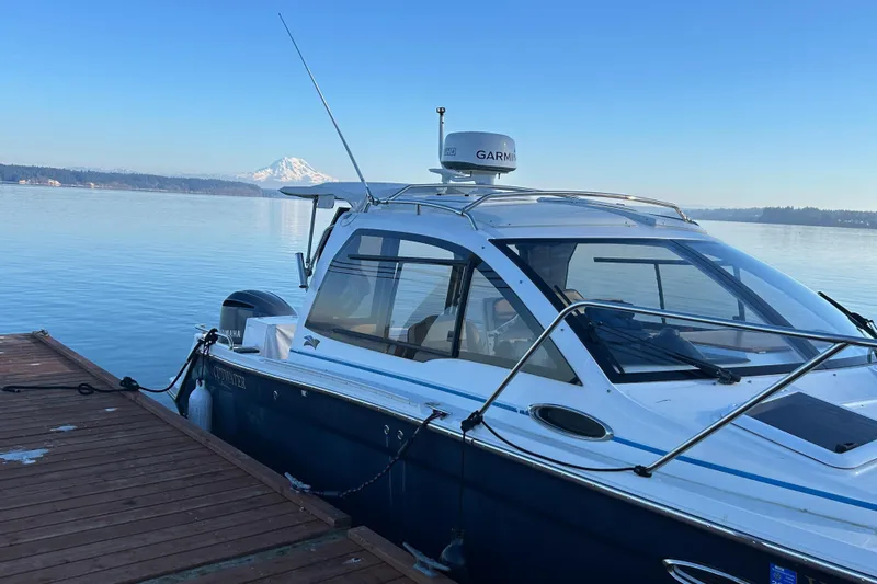 Slide: The Image of 2017 Cutwater C-24 boat docked on calm water with mountain view. - 2