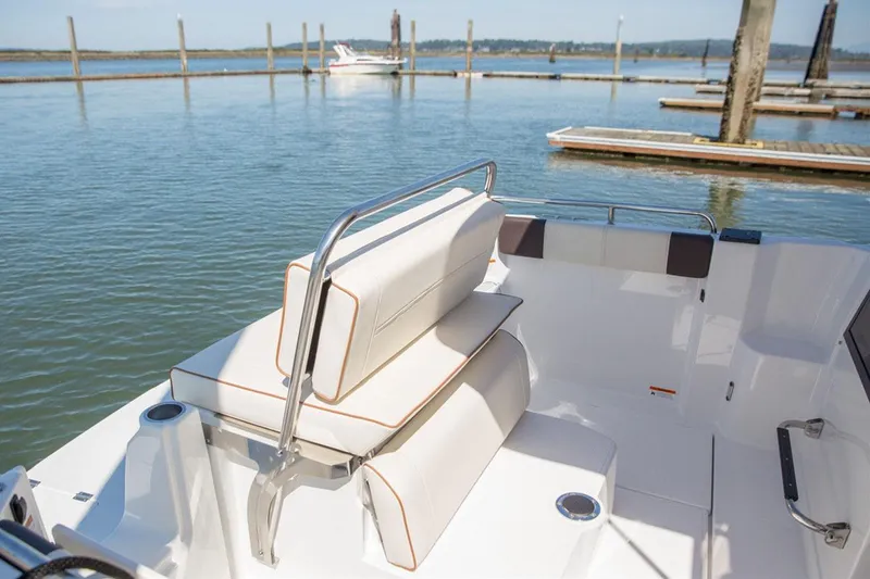 The Image of Manufacturer Provided Image: 2017 Cutwater C-24 boat interior with white cushioned seating at a marina. - 6