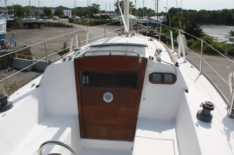 Slide: The Image of 1981 S2 9.2A sailboat cockpit with wooden hatch, docked in a marina setting. - 15