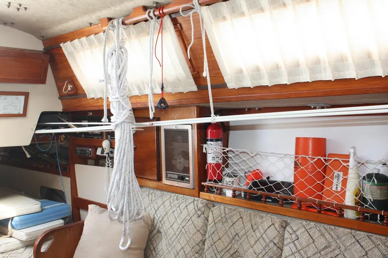 Slide: The Image of Interior of 1981 S2 9.2A sailboat with ropes, fire extinguisher, and storage netting. - 32