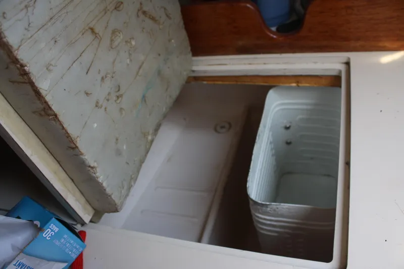 Slide: The Image of Open storage compartment on 1981 S2 9.2A sailboat with visible container inside. - 37