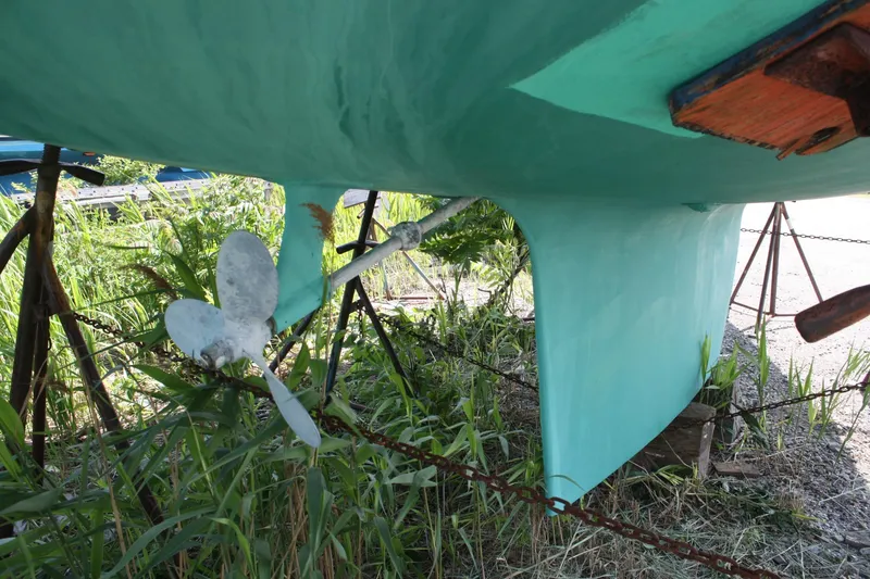 Slide: The Image of 1981 S2 9.2A sailboat hull and propeller on stands, surrounded by greenery. - 7