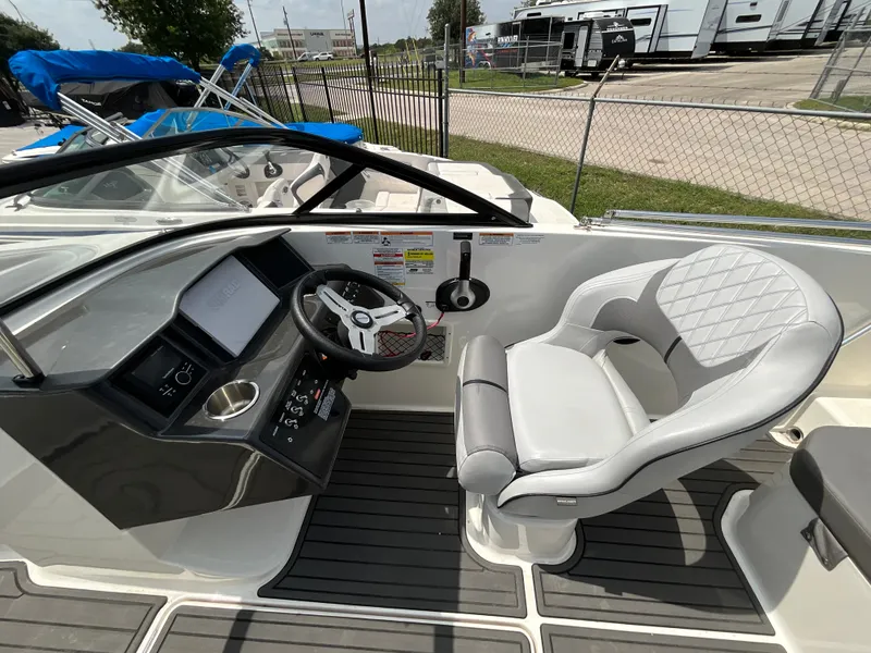Slide: The Image of The image shows the cockpit of a 2023 Bayliner VR5 with a sleek helm and cushioned seat. - 9