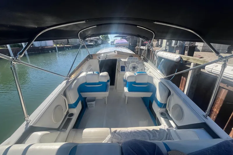 Slide: The Image of 1994 Fountain 42 Lightning boat interior with blue and white seating, docked in a canal. - 10