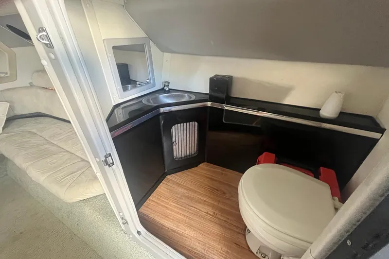 Slide: The Image of Interior of 1994 Fountain 42 Lightning boat featuring a compact bathroom with sink and toilet. - 24