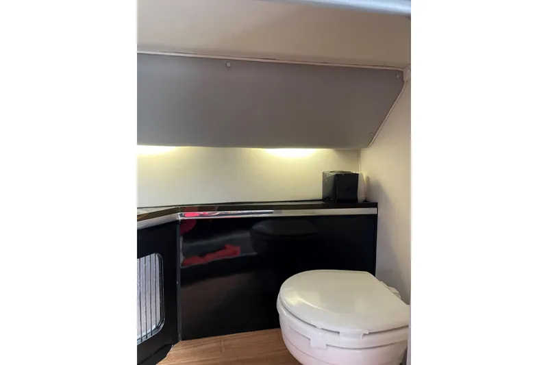 Slide: The Image of Interior of 1994 Fountain 42 Lightning boat featuring a compact bathroom area. - 25