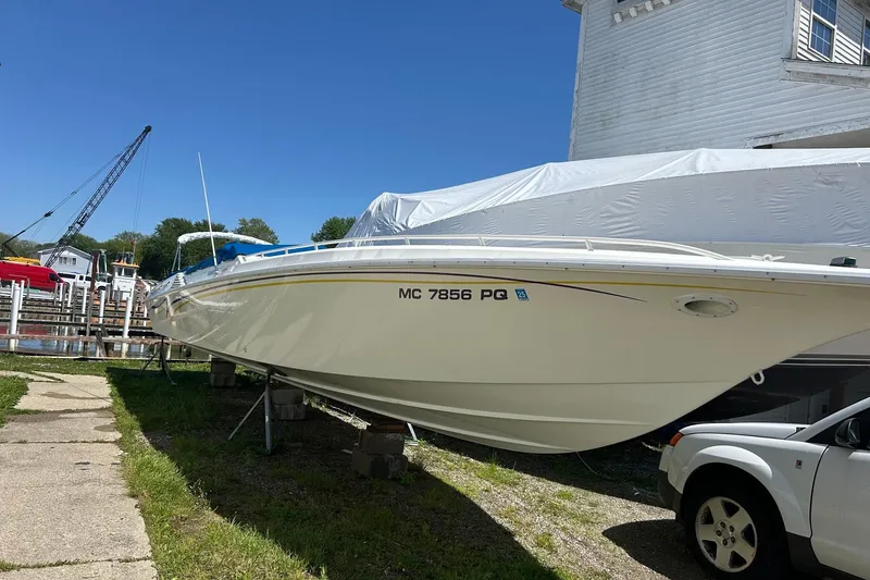Slide: The Image of 1994 Fountain 42 Lightning boat on land, near marina, under clear blue sky. - 4