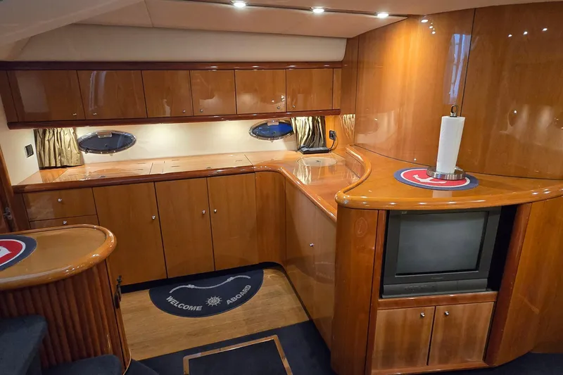 Slide: The Image of Luxurious 2004 Sunseeker Camargue 50 yacht interior with polished wood cabinetry and modern amenities. - 31