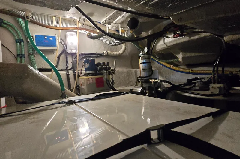 Slide: The Image of Engine room of a 2004 Sunseeker Camargue 50 yacht, showcasing mechanical components and wiring. - 48