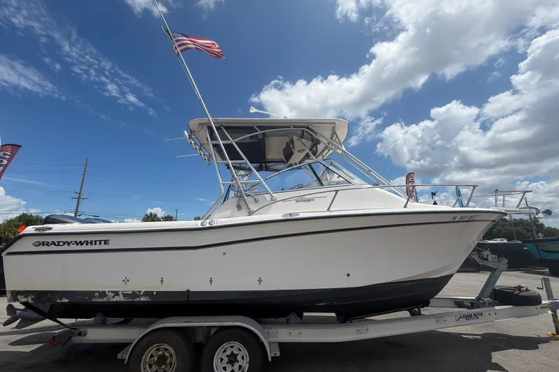 Slide: The Image of 2000 Grady-White Express 265 boat on trailer under blue sky with American flag. - 1