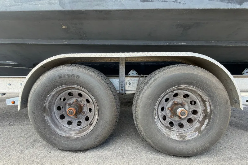 Slide: The Image of Trailer wheels for 2000 Grady-White Express 265 boat on pavement. - 115