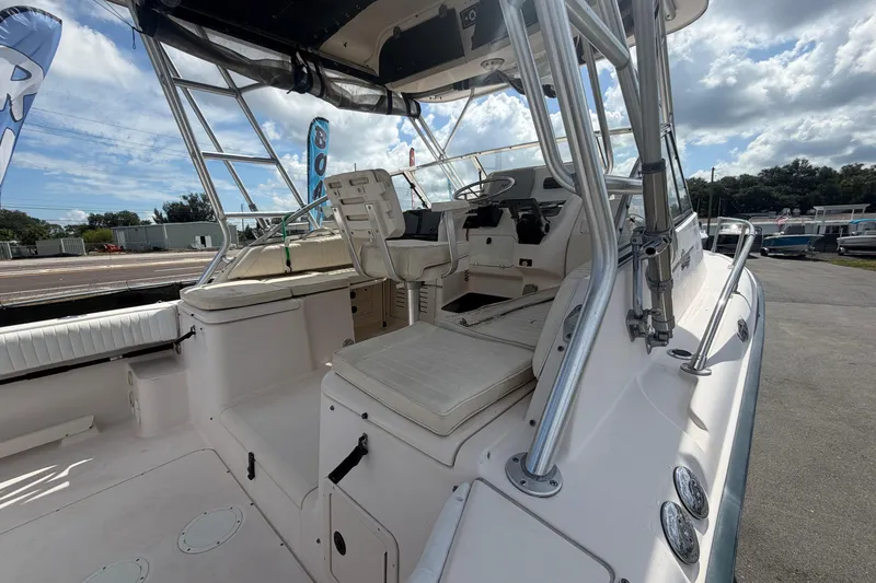 Slide: The Image of 2000 Grady-White Express 265 boat interior with seating and helm, under a cloudy sky. - 18