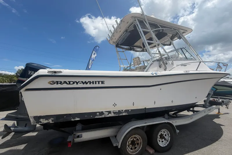 Slide: The Image of 2000 Grady-White Express 265 boat on trailer under a cloudy sky. - 2