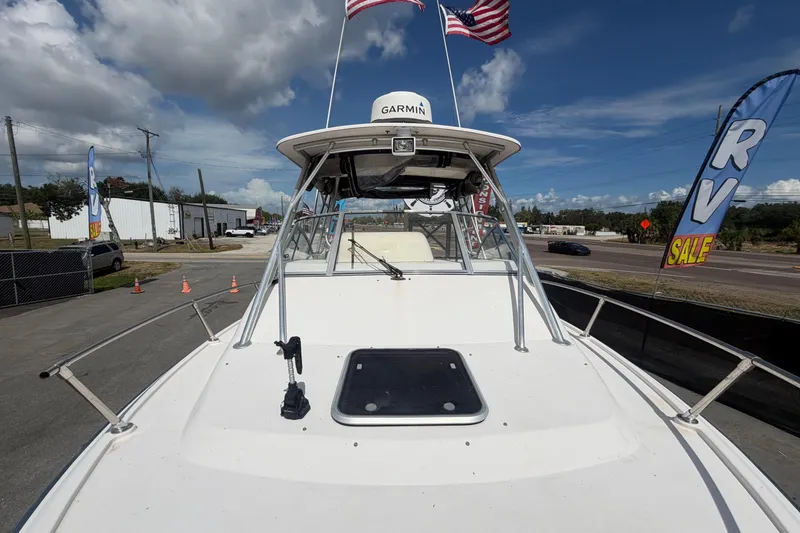 Slide: The Image of 2000 Grady-White Express 265 boat with Garmin equipment, displayed outdoors under a cloudy sky. - 25