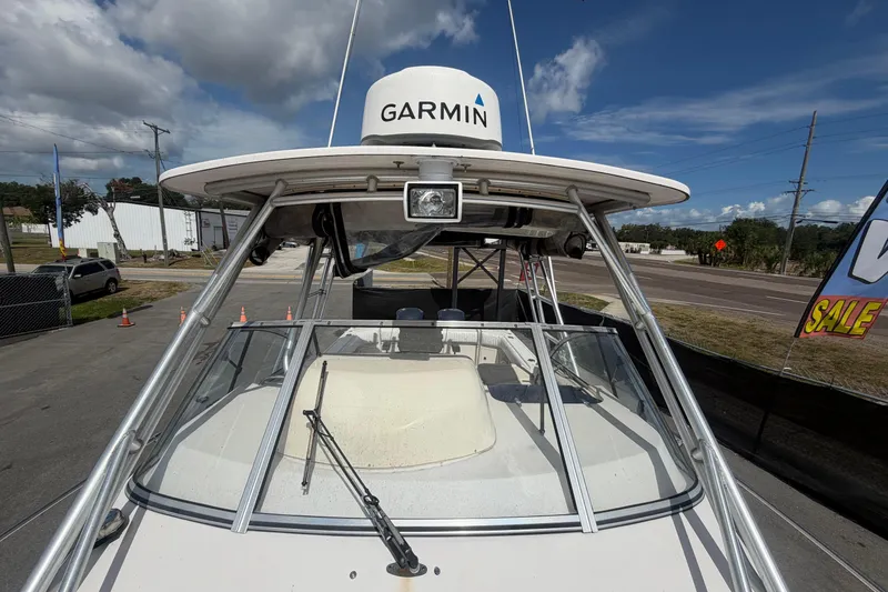 Slide: The Image of 2000 Grady-White Express 265 boat with Garmin radar, parked outdoors under a cloudy sky. - 26