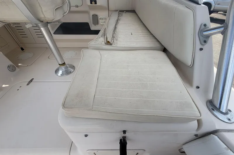 Slide: The Image of Interior seating of a 2000 Grady-White Express 265 boat, featuring white cushioned seats. - 35