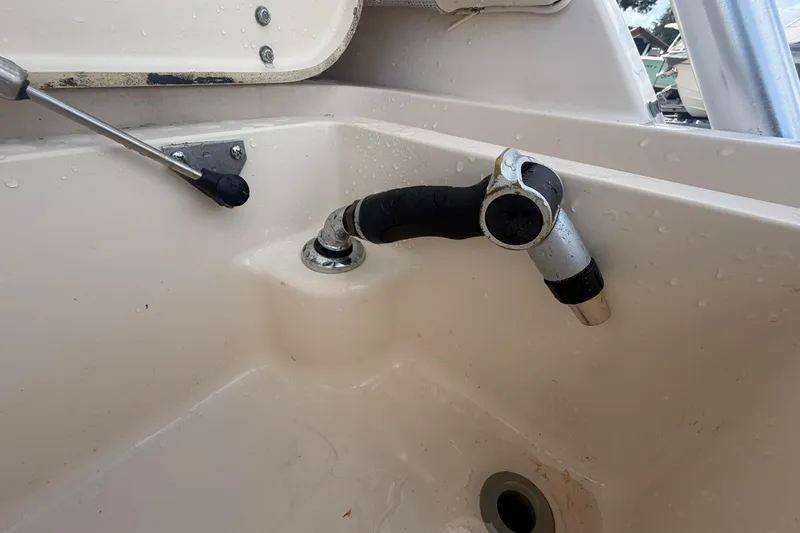 Slide: The Image of Grady-White Express 265 boat sink with faucet, 2000 model, featuring a clean, white basin. - 37