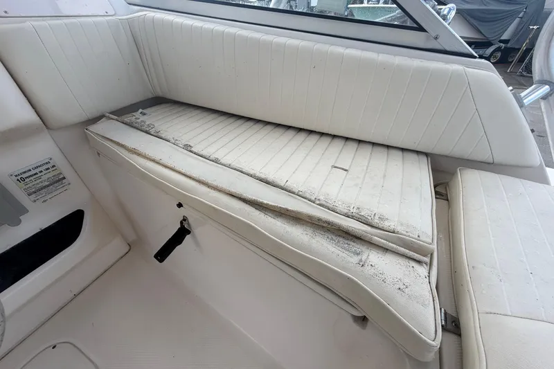 Slide: The Image of Interior seating of a 2000 Grady-White Express 265 boat, showing worn white upholstery. - 38