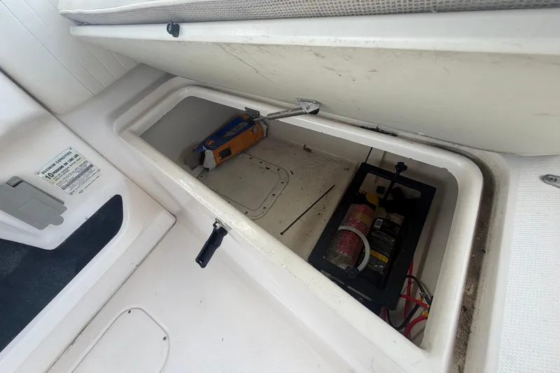 Slide: The Image of Storage compartment in a 2000 Grady-White Express 265 boat, containing tools and equipment. - 39