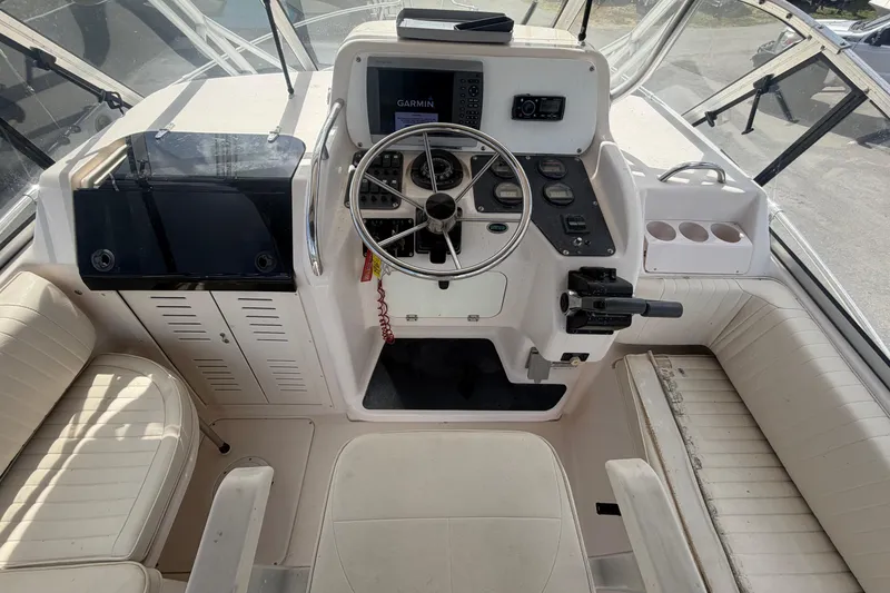 Slide: The Image of Cockpit of 2000 Grady-White Express 265 boat with steering wheel and navigation equipment. - 42